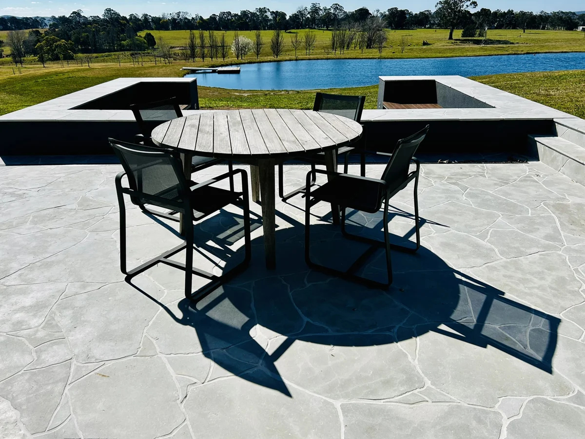 Paved terrace with built-in seating overlooking a dam