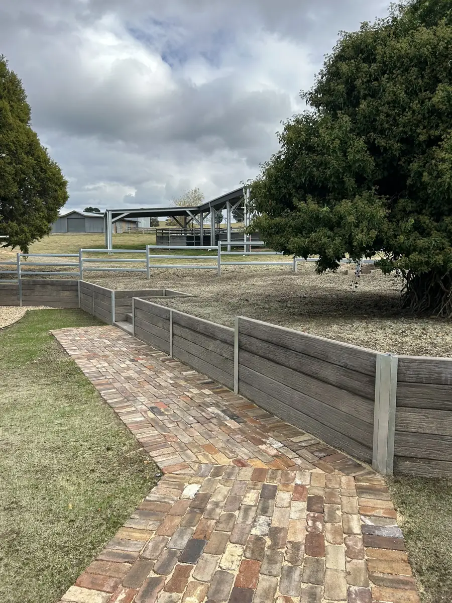 Brick path beside timber retaining walls and lawn